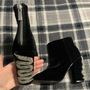 Black heeled boots with snake designs on heel
